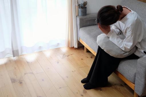 ソファーで祈る40代の写真