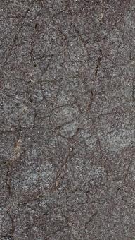 風化しひび割れたコンクリートの地面の写真