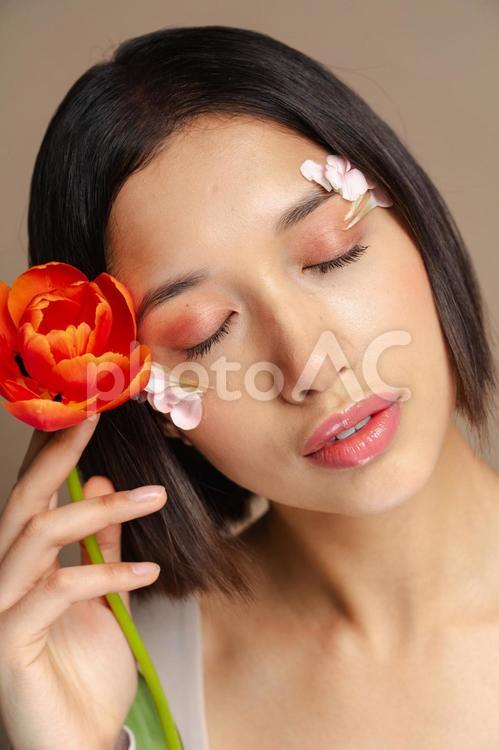 チューリップを持ち目を瞑る女性 女性,目を瞑る,チューリップの写真素材