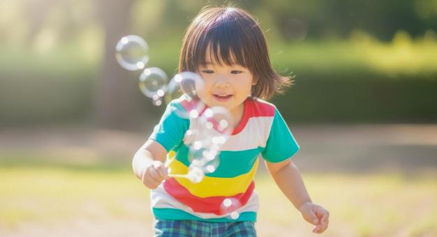 シャボン玉で遊ぶ笑顔の男の子の写真