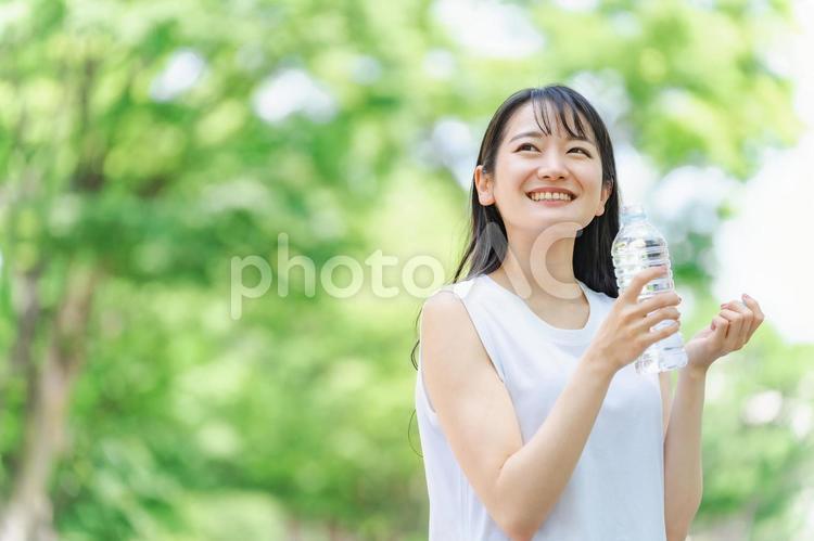 新緑の中で水分補給をする女性 水分補給,水,新緑の写真素材