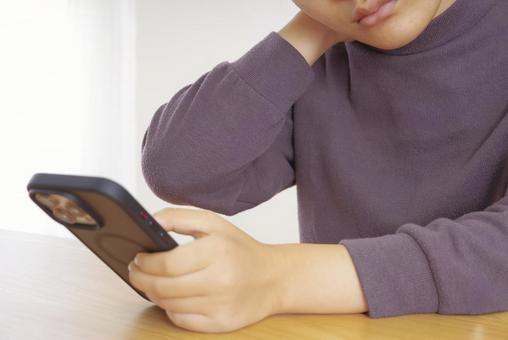 首・肩が痛そうにスマホを操作している女性 スマホ首,ストレートネック,スマホの写真素材