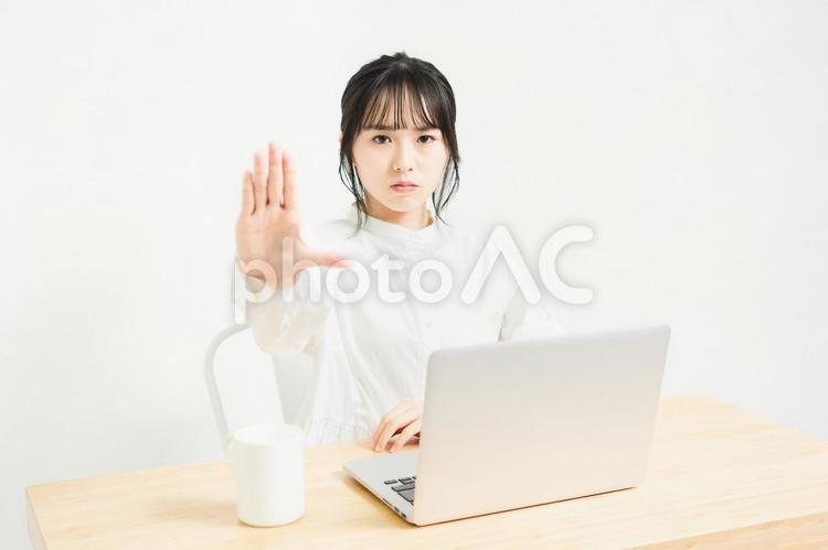 PCを使いながらNGのサインをする女性 ng,女の子,若いの写真素材