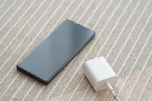 Smartphone and charging cord on the carpet, JPG Smartphone and charging cord on the carpet, JPG