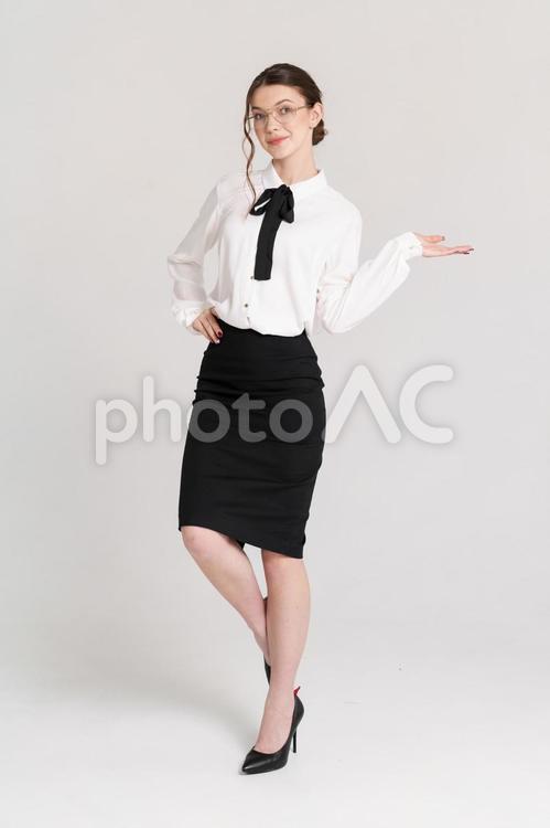 カメラ目線で案内する外国人女性 女性,腰に手,ジェスチャーの写真素材