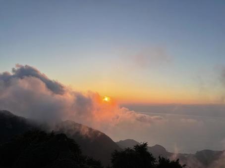 弥彦山の展望台から見た夕日が雲に隠れた 弥彦山の展望台から見た夕日が雲に隠れたの写真