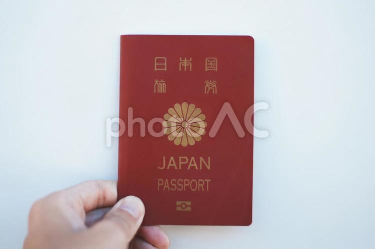 日本国のパスポートを持つ人の手元と白背景 パスポート,旅券,旅行の写真素材