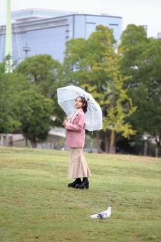 小雨の公園を散策する女性 女性,可愛い,20代の写真素材