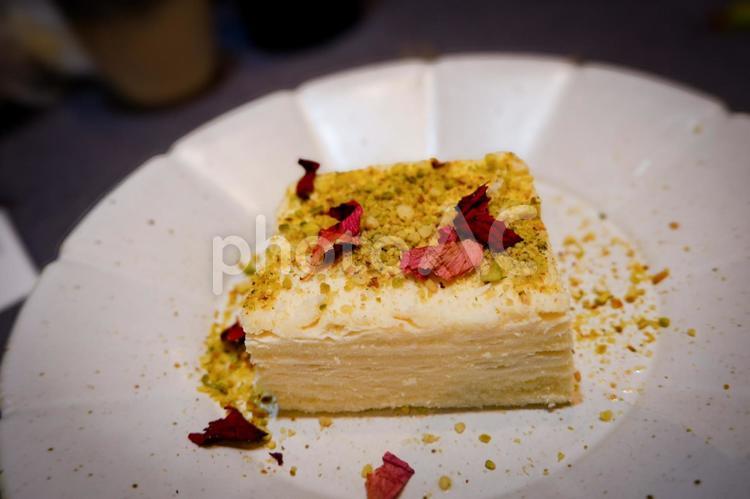 ピスタチオと花びらが彩るケーキのアップ スイーツ,ケーキ,デザートの写真素材
