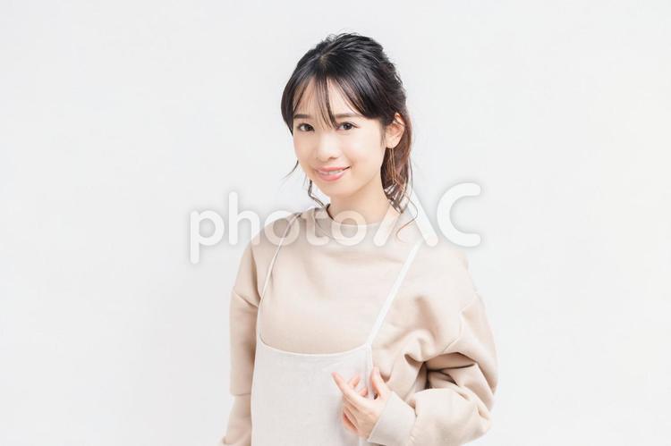 白い背景の前に立ってポーズをとる若い女性 女性,白背景,立つの写真素材