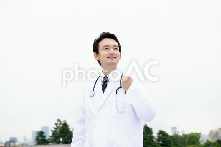 遠くを見る男性医師 医療従事者,男性,ガッツポーズの写真素材