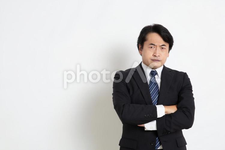 腕組みをして怒っている中年のサラリーマン男性（コピースペース） 中年,上司,会社員の写真素材