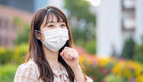 マスクをして辛そうにしている日本人女性 マスクをして辛そうにしている日本人女性の写真