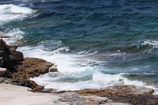 岩場の海岸と白波の波打ち際と青い海の風景 岩場の海岸と白波の波打ち際と青い海の風景の写真