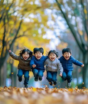 秋の公園でジャンプする子どもたち 秋の公園でジャンプする子どもたちの写真
