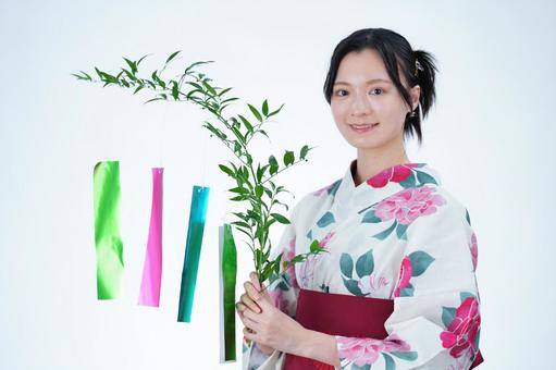 浴衣姿の女性が笹飾りの前に立つ 女性,浴衣,七夕の写真素材
