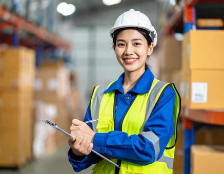倉庫で在庫をチェックする女性作業員 倉庫で在庫をチェックする女性作業員の写真