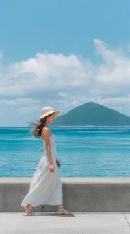 島を眺めながら歩く女性のポートレート 島を眺めながら歩く女性のポートレートの写真
