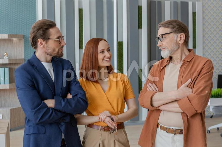 立って話をしている3人のビジネスパーソン ビジネスマン,ビジネスウーマン,男性の写真素材