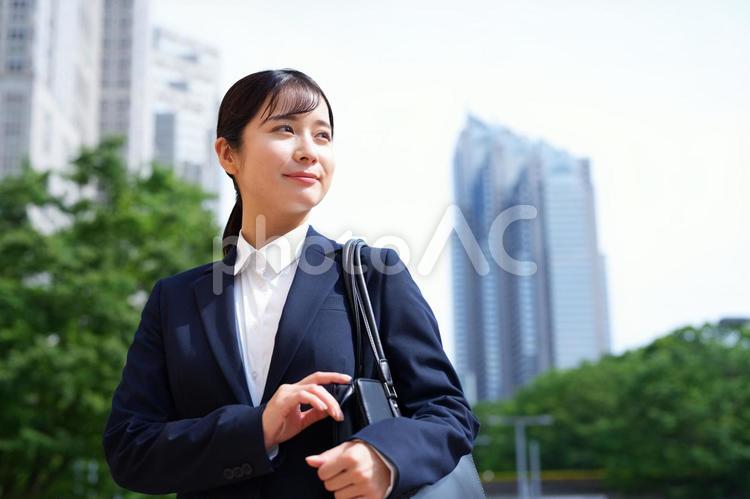 オフィス街で遠くを見る女性 女性,人物,大学生の写真素材