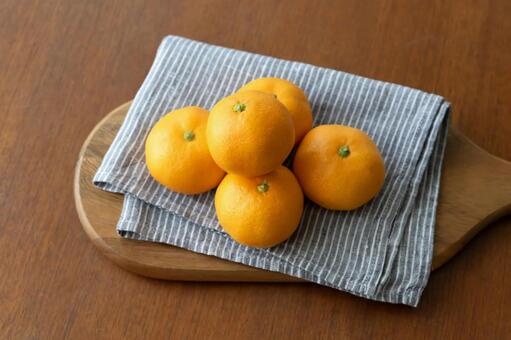 ボードとリネンに乗せたみかん　木目背景 みかん,果物,柑橘類の写真素材