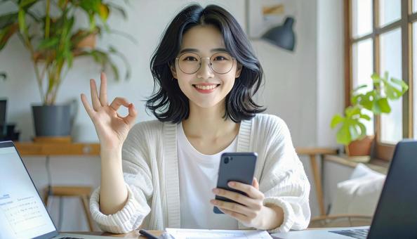 家計がうまくいきスマホ片手に微笑む女性 家計がうまくいきスマホ片手に微笑む女性の写真