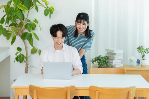 パソコンを見るカップル ノートパソコン,笑顔,カップルの写真素材