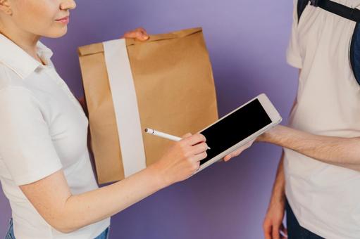 受取サインを貰うフードデリバリーの男性 配達,デリバリー,配送の写真素材