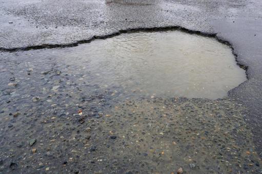 アスファルトに開いた穴（雨）04 アスファルト,道路,駐車場の写真素材