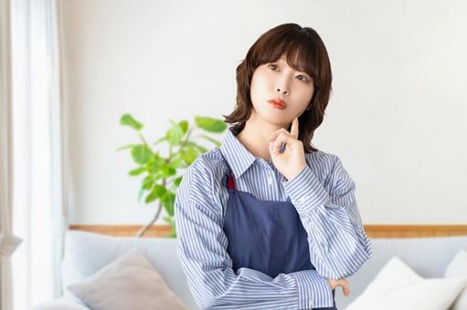 考えごとをするエプロン姿の女性 考えごとをするエプロン姿の女性 女性,考える,困るの写真素材