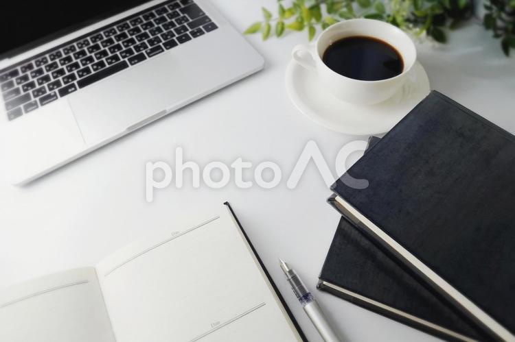 パソコン、本、コーヒー、手帳の置かれたデスク周り パソコン,コーヒー,本の写真素材