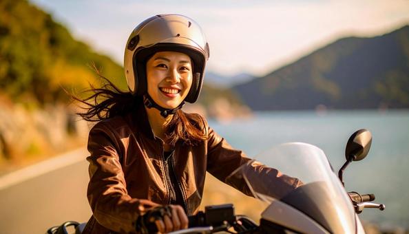 休日に海辺をバイクでツーリングする女性 休日に海辺をバイクでツーリングする女性の写真