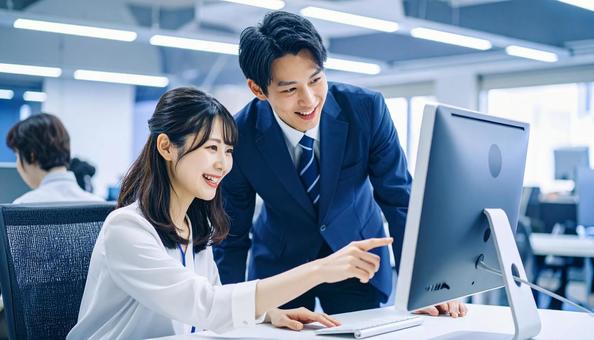 パソコンを見ながら打ち合わせをする社員 パソコンを見ながら打ち合わせをする社員の写真