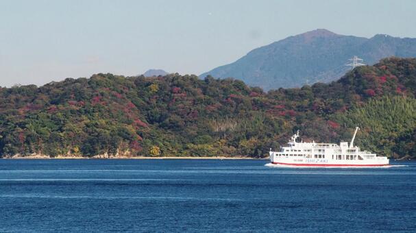 紅葉した島をバックにフェリーが進む 灯台,フェリー旅,船旅の写真素材