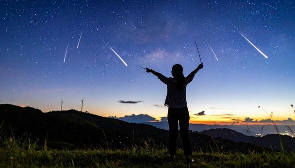流星群を見る人のシルエット 流星群を見る人のシルエットの写真