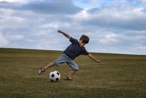 ＜素材＞山頂で元気にサッカーをする男の子 子供,サッカー,運動の写真素材
