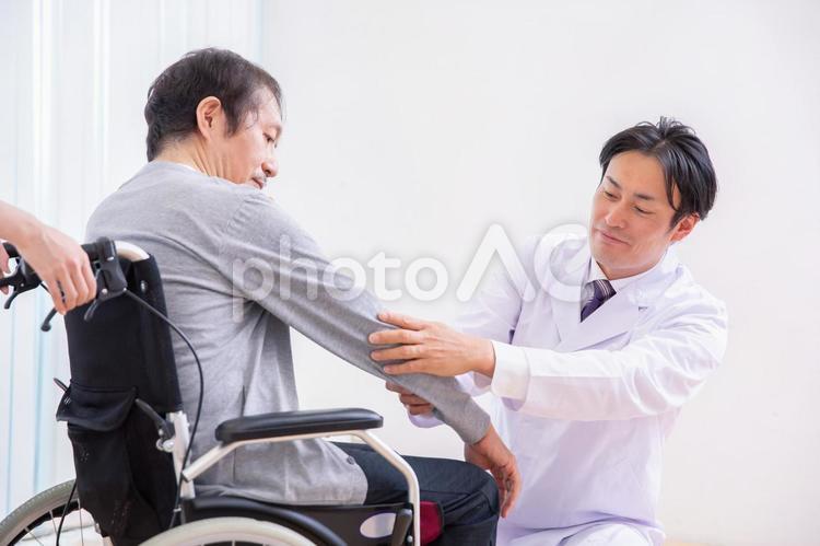 車椅子に乗る患者と医者（腕） 医者,介護士,車椅子の写真素材