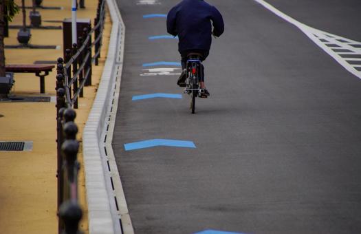 車道上の自転車レーンを走行する自転車 自転車ナビライン,自転車ナビマーク,法定外表記の写真素材