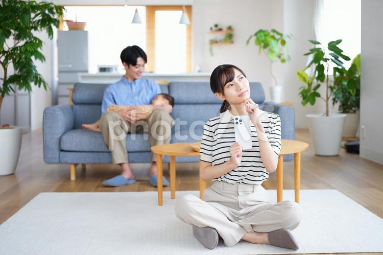 胡坐でスマホを持ち悩む女性 女性,スマートフォン,持つの写真素材