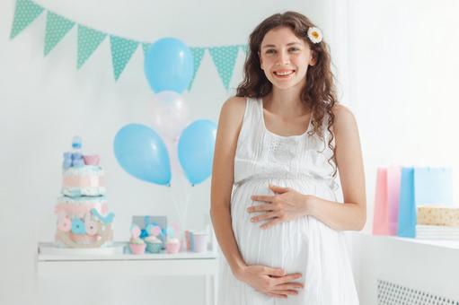 笑顔でお腹を触る髪飾りの女性 笑顔でお腹を触る髪飾りの女性の写真