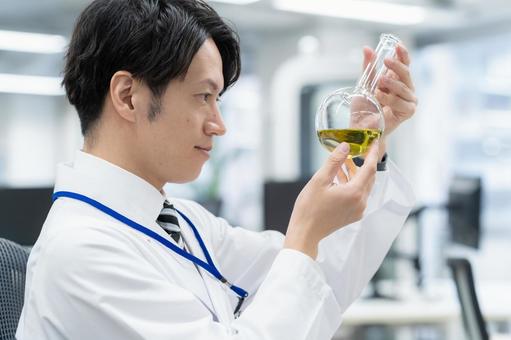 実験をする白衣の若い男性研究者 実験をする白衣の若い男性研究者 研究,実験,サイエンスの写真素材
