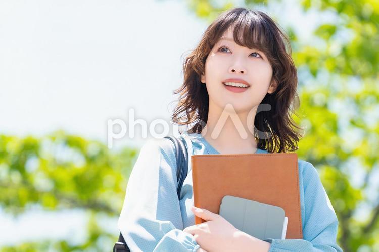 屋外を歩く笑顔の女性・ビジネスウーマン 女性,歩く,緑の写真素材