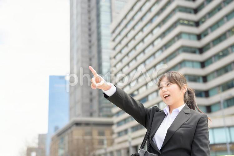 大きく指をさす女性 スーツ,新入社員,フレッシャーズの写真素材