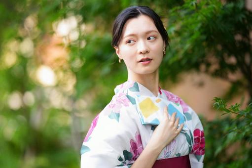 浴衣姿の女性が横を向いて立つ 女性,浴衣,ハンカチの写真素材