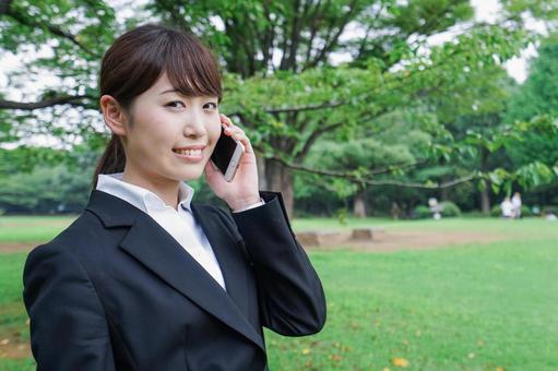 電話をするスーツ姿の若い女性 電話をするスーツ姿の若い女性 女,スマートフォン,笑顔の写真素材