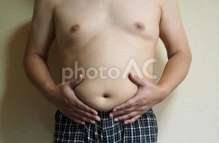 お腹を気にする半裸の男性 半裸,裸,男性の写真素材