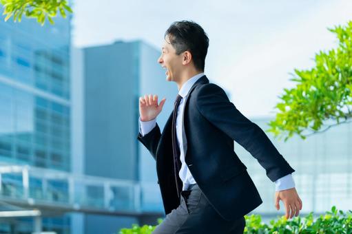 オフィス街を走る男性ビジネスマン 男性,ビジネス,ビジネスマンの写真素材