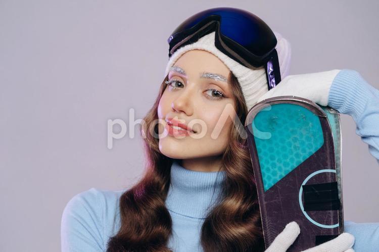 カメラ目線でスキー板を持つ女性の上半身 冬,スポーツ,ウィンタースポーツの写真素材