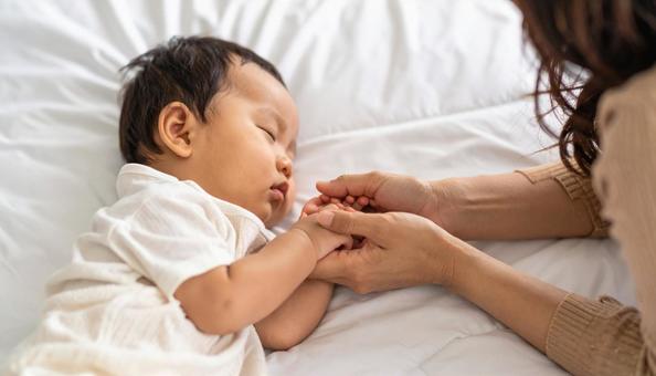 赤ちゃんの手を握る日本人お母さんの手 赤ちゃんの手を握る日本人お母さんの手の写真