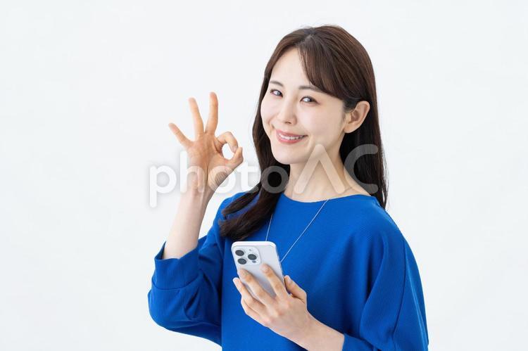 スマホを持ってOKサインの若い女性 ok,スマホ,成功の写真素材